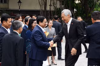 Thủ tướng Phạm Minh Chính và lãnh đạo Đại học Quốc gia Hà Nội đón Thủ tướng Singapore Lý Hiển Long cùng phu nhân.