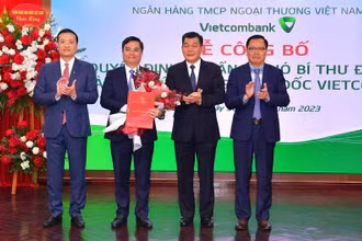 Phó Bí thư Thường trực Đảng ủy Khối doanh nghiệp Trung ương Nguyễn Đức Phong (thứ 2 từ phải sang) trao Quyết định của Đảng ủy Khối doanh nghiệp Trung ương và Chủ tịch HĐQT Vietcombank Phạm Quang Dũng (ngoài cùng bên trái) tặng hoa chúc mừng.