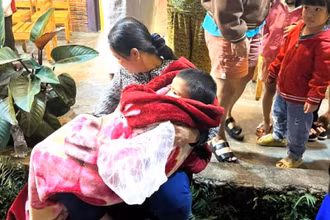 Cháu Đ được người thân chăm sóc sau khi cứu lên khỏi giếng nước.