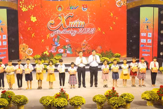 Phó Bí thư Thường trực Tỉnh ủy, Chủ tịch Hội đồng nhân dân tỉnh Hậu Giang Trần Văn Huyến (bên trái) và Phó Giáo sư, tiến sĩ Nguyễn Quốc Dũng, Giám đốc Học viện Chính trị khu vực II, trao quà cho các cháu.