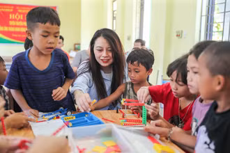 Các em bé háo hức với những món đồ chơi được tặng. (Ảnh: NAM NGUYỄN)