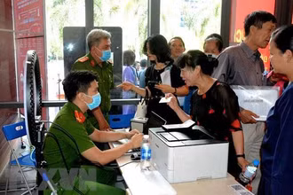 Công an làm căn cước công dân gắn chíp cho người dân tại điểm dịch vụ công trực tuyến. (Ảnh: TTXVN)