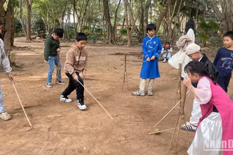 Các em nhỏ thử chơi trò chơi dân gian của người Mường.