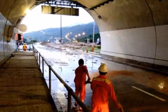 Lực lượng quản lý hầm Hải Vân nỗ lực suốt đêm dọn đất cát, bùn đá sau khi lũ quét. (Ảnh: ĐN)