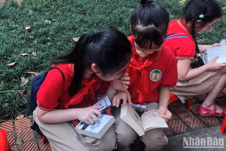 Các em nhỏ đọc sách trong khuôn viên Thư viện Quốc gia.