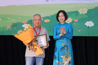 Tổng Giám đốc Thông tấn xã Việt Nam Vũ Việt Trang trao giải Hiệp sĩ Dế Mèn cho nhà văn Trần Đức Tiến. (Ảnh: Ban tổ chức)