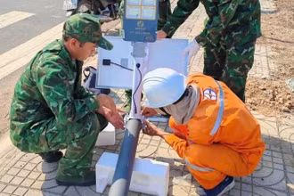 Cán bộ, chiến sĩ Đồn Biên phòng Bo Heng và cán bộ, nhân viên Điện lực thi công công trình.