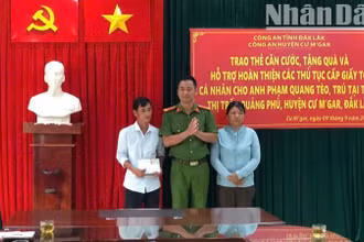 Thượng tá Lê Văn Khánh, Phó Trưởng Công an huyện Cư M'gar trao căn cước công dân và số tiền do cán bộ, chiến sĩ Công an huyện quyên góp tặng cho vợ chồng anh Phạm Quang Tèo.