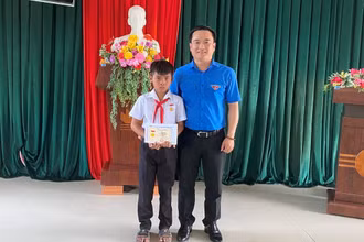 Anh Đỗ Duy Nam trao huy hiệu "Tuổi trẻ dũng cảm" cho em Kpă Nguyên. 