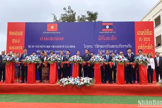 Các đại biểu thực hiện nghi thức khánh thành, đưa vào sử dụng Học viện Kinh tế-Tài chính Dongkhamxang. (Ảnh: HẢI TIẾN)