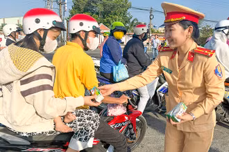 Lực lượng cảnh sát giao thông Công an tỉnh Vĩnh Long tặng nước suối và sữa cho người đi đường