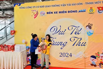 Hành khách có con nhỏ nhận quà Trung thu tại Bến xe Miền Đông mới (Thành phố Thủ Đức), Thành phố Hồ Chí Minh. (Ảnh: QUÝ HIỀN)