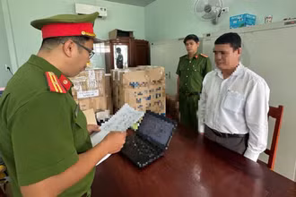 Lực lượng chức năng thi hành Lệnh khởi tố bị can Lê Minh Việt, Chủ tịch Ủy ban nhân dân xã Đức Lợi, huyện Mộ Đức. (Ảnh Công an Quảng Ngãi cung cấp)