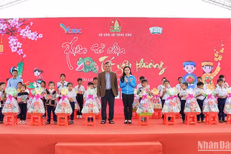 Bí thư Trung ương Đoàn, Chủ tịch Hội đồng Đội Trung ương Nguyễn Phạm Duy Trang (áo xanh) cùng đại diện các đơn vị liên quan trao quà Tết tặng thiếu nhi có hoàn cảnh khó khăn tại ngày hội.