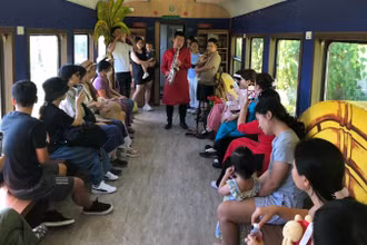 Biểu diễn văn nghệ phục vụ hành khách trên toa cộng đồng.
