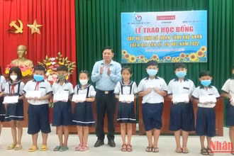 Chủ tịch Hội Nhà báo tỉnh Bến Tre Nguyễn Hữu Thọ trao học bổng cho học sinh nghèo, học giỏi.