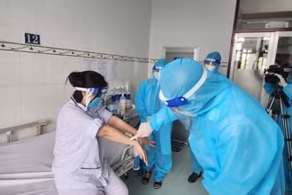 Lãnh đạo Cục Y tế dự phòng, Bộ Y tế thăm hỏi, động viên người bệnh mắc đậu mùa khỉ. (Ảnh: TTXVN)