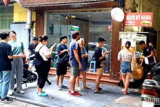 Du khách nước ngoài đứng xếp hàng mua bánh mỳ tại một cửa hàng trên phố Lý Quốc Sư, Hà Nội. (Ảnh: T.LINH)