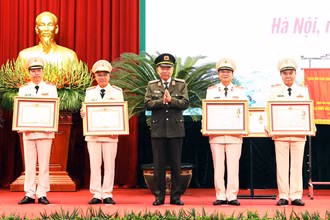 Bộ trưởng Công an Tô Lâm trao phần thưởng của Đảng Nhà nước cho cán bộ Công an thành phố có thành tích xuất sắc.