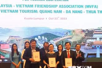 Đại diện Trung tâm Xúc tiến du lịch 3 tỉnh thành Quảng Nam-Đà Nẵng-Thừa Thiên Huế và Chủ tịch Hội Hữu nghị Malaysia–Việt Nam (giữa) ký kết biên bản ghi nhớ hợp tác truyền thông và quảng bá du lịch. (Ảnh: TTXVN)