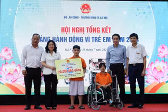 Thứ trưởng Nguyễn Thị Hà tặng quà cho trẻ em tại Trung tâm Phục hồi chức năng người khuyết tật Thụy An. (Ảnh: Molisa) 