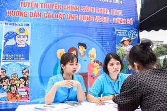 Cán bộ Bảo hiểm xã hội quận Long Biên, Hà Nội giới thiệu chính sách với người lao động. (Ảnh: NGÂN ANH)