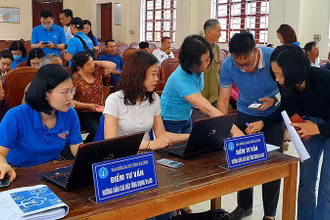 Cán bộ bảo hiểm xã hội hướng dẫn người dân cài đặt VssID. (Ảnh: Tâm Trung)