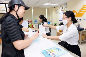 Giao dịch viên của Vietnam Post tư vấn cho khách hàng về thông tin chương trình Khuyến mại nhân Kỷ niệm 15 năm Thành lập LienVietPostBank. (Ảnh: Vietnam Post)