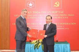 Ông Lê Hoài Trung, Ủy viên Trung ương Đảng, Trưởng Ban Đối ngoại Trung ương và ông Miguel Mejia, Tổng Bí thư Đảng Phong trào cánh tả thống nhất Dominica trao bản thỏa thuận hợp tác giữa hai Đảng. (Ảnh: TTXVN)