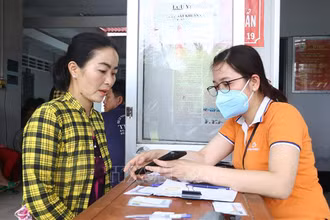 Thành viên Tổ công nghệ số cộng đồng tỉnh Sóc Trăng giúp người dân cài đặt ứng dụng VNeID. (Ảnh: TUẤN PHI)