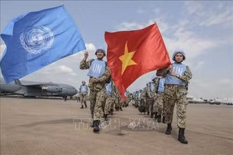Các bác sĩ quân y Việt Nam giương cao hai lá cờ của Liên hợp quốc và Việt Nam tại sân bay quốc tế Juba, bắt đầu thực hiện nhiệm vụ gìn giữ hòa bình Liên hợp quốc tại Nam Sudan. (Ảnh: TTXVN)