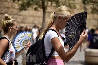 Người dân làm mát khi nhiệt độ lên cao tại Seville, Tây Ban Nha ngày 13/6/2022. (Nguồn: AFP/TTXVN)