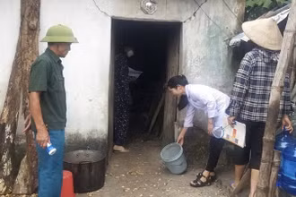 Cán bộ y tế hướng dẫn người dân vệ sinh môi trường sau bão, lụt trên địa bàn huyện Ứng Hòa, Hà Nội.