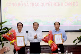 Phó Chủ tịch Ủy ban nhân dân tỉnh Đồng Tháp Đoàn Tấn Bửu trao quyết định cho ông Trần Tấn Lực (bìa phải) và ông Nguyễn Duy Trung. (Ảnh: NGUYỆT ÁNH) 
