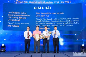 Đồng chí Lê Quốc Minh, Ủy viên Trung ương Đảng, Tổng Biên tập Báo Nhân Dân, Phó Trưởng ban Tuyên giáo Trung ương, Chủ tịch Hội Nhà báo Việt Nam và đồng chí Nguyễn Văn Thắng, Ủy viên Trung ương Đảng, Bộ trưởng Giao thông vận tải trao giải Nhất cho các tác giả. (Ảnh: Tạ Hải)