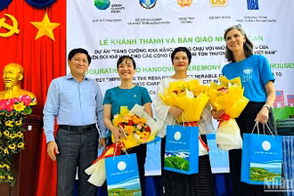 Đại diện lãnh đạo tỉnh Cà Mau tặng hoa cảm ơn các đơn vị đồng hành hỗ trợ nhà cho cư dân vùng ven biển.