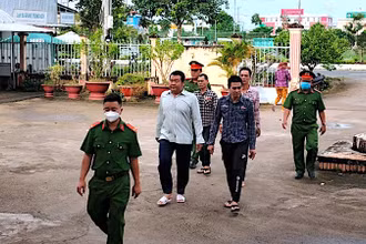 Nhóm bị can hành hạ người khác bị lực lượng Công an áp giải để đưa ra xét xử trước tòa. 