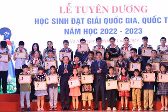 Đồng chí Phạm Tất Thắng và đồng chí Ngọ Duy Hiểu trao khen thưởng cho các em học sinh.