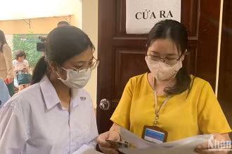Giám thị gọi thí sinh vào phòng thi theo số báo danh tại điểm thi Trường đại học Sư phạm Hà Nội. (Ảnh: THÚY QUỲNH)