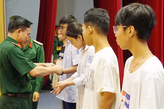 Đại tá Nguyễn Tiến Quang, Chính ủy Bộ Chỉ huy quân sự tỉnh Thái Bình trao quà cho các cháu học sinh có hoàn cảnh khó khăn đạt thành tích cao trong học tập. 