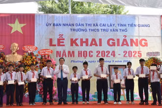 Trưởng Ban Tuyên giáo Trung ương Nguyễn Trọng Nghĩa tặng học bổng cho các em học sinh nghèo nhân dịp lễ khai giảng. 
