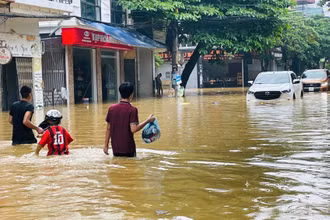 Người dân chạy lũ tại đường Thành Công, phường Nguyễn Thái Học, thành phố Yên Bái. (Ảnh: THANH SƠN)
