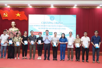 Tổng Giám đốc Nguyễn Thế Mạnh, Phó Chủ tịch Ủy ban nhân dân tỉnh Yên Bái Vũ Thị Hiền Hạnh trao tặng sổ bảo hiểm xã hội, thẻ bảo hiểm y tế cho người dân có hoàn cảnh khó khăn ở huyện Yên Bình. (Ảnh: VSS)