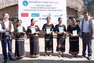 Phó Tổng Giám đốc Bảo hiểm xã hội Việt Nam Chu Mạnh Sinh trao sổ bảo hiểm xã hội, thẻ bảo hiểm y tế tặng người dân xã Đăk La, huyện Đăk Hà, Kon Tum. (Ảnh: KSS)