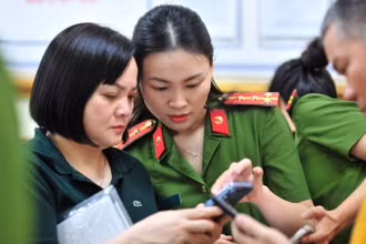 Công an thành phố Hà Nội hướng dẫn người dân tích hợp ứng dụng VNeID. (Ảnh HOÀNG PHONG)