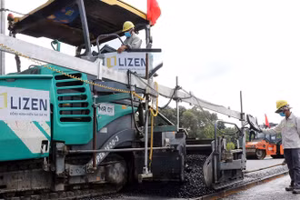 Nhà thầu tiến hành thảm nhựa lớp đầu tiên tại gói thầu số 21, thuộc dự án thành phần 1, đường cao tốc Biên Hòa-Vũng Tàu, đoạn qua tỉnh Đồng Nai. (Ảnh Công Phong)