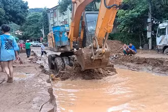 Lực lượng chức năng san gạt bùn đất do lũ quét để sớm thông quốc lộ 7, đoạn qua thị trấn Mường Xén (Kỳ Sơn).