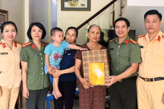 Đại diện đoàn công tác trao tặng quà cho trẻ em cùng gia đình.
