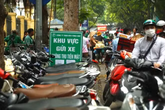 Điểm trông giữ xe máy hạn chế dùng tiền mặt trên phố Phủ Doãn.