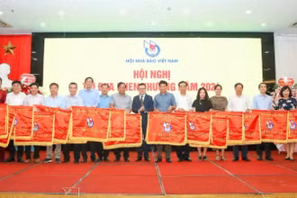 Chủ tịch Hội Nhà báo Việt Nam Lê Quốc Minh trao Cờ thi đua tặng tập thể có thành tích xuất sắc.